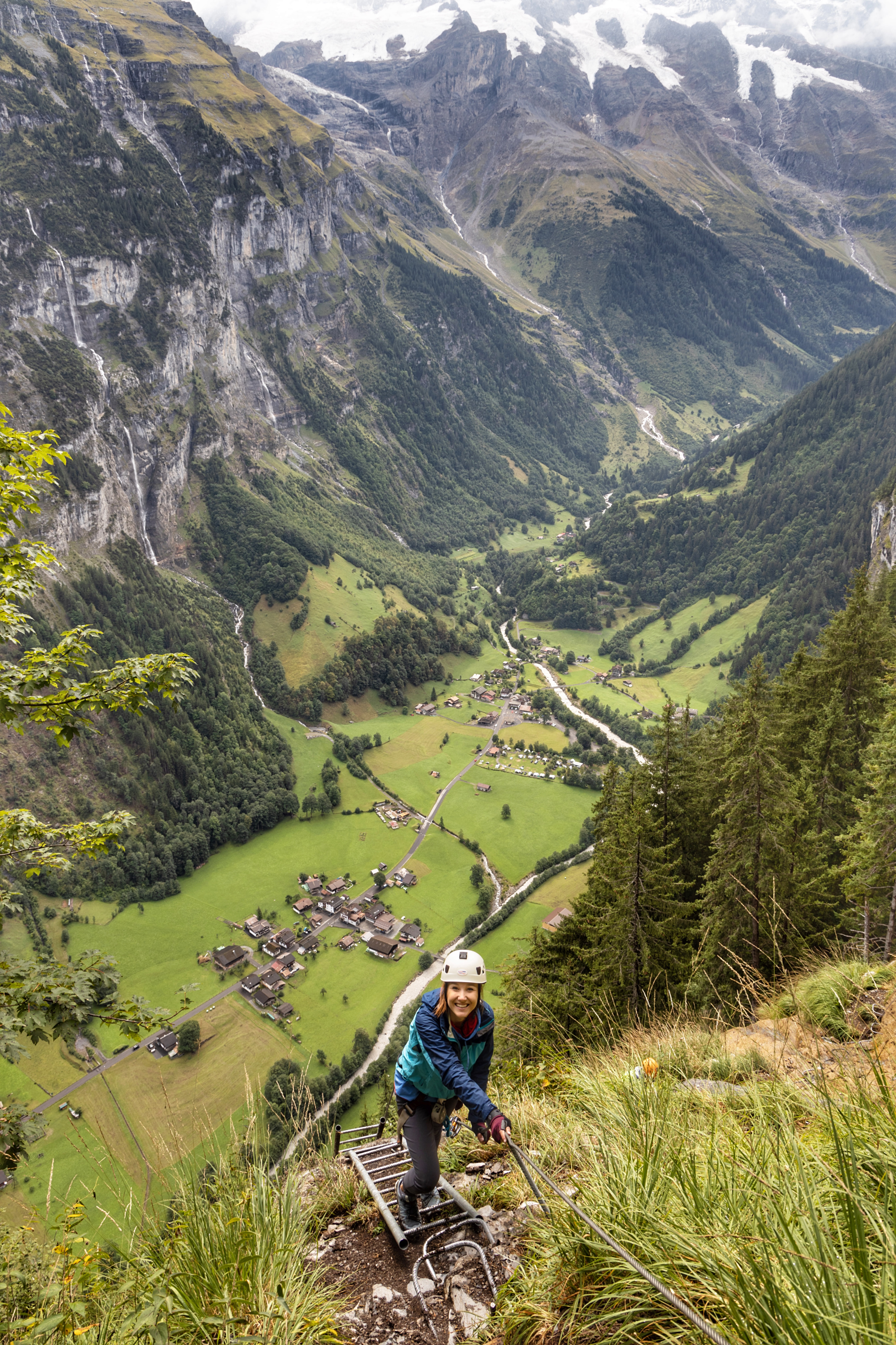 Jana climbing down a ladder from murren to gimmelwald switzerland on a via ferrata adventure