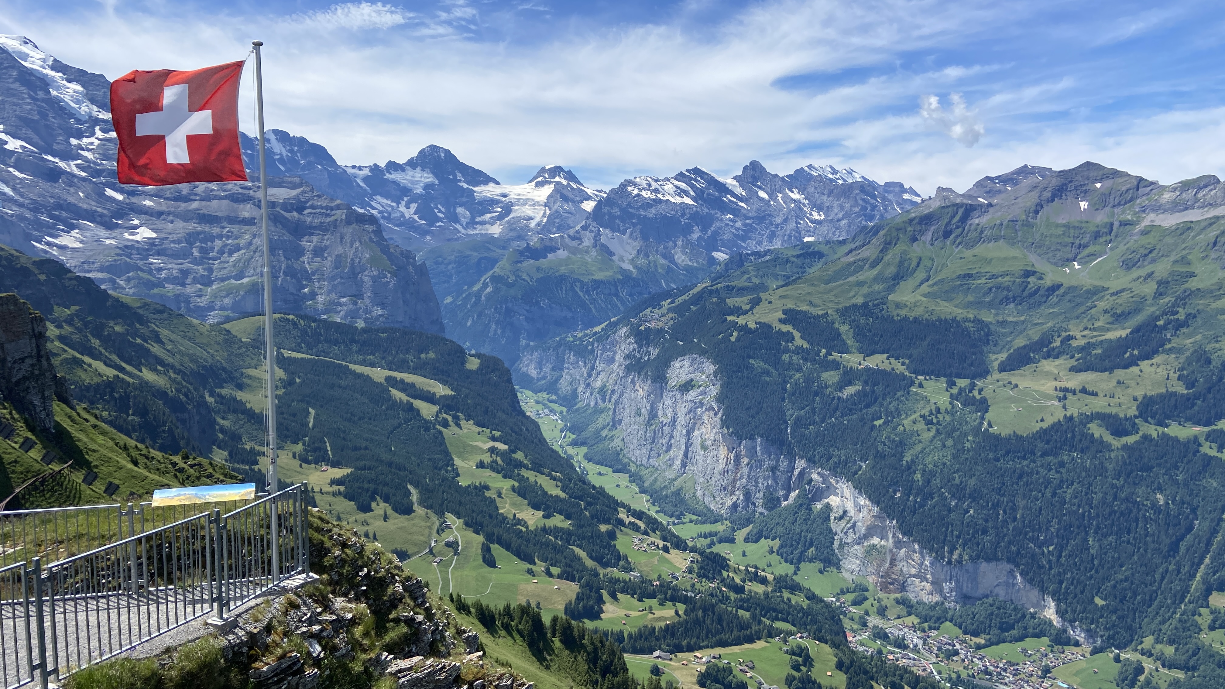 Mannlichen overlooking Lauterbrunnen Valley and Wengen, Switzerland with swiss flag