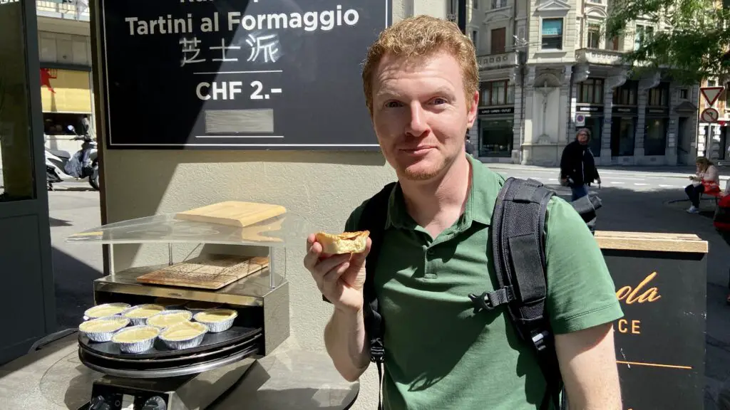 Brett enjoying Chäs Chüechli cheese pie from Chäs Barmettler in lucerne switzerland