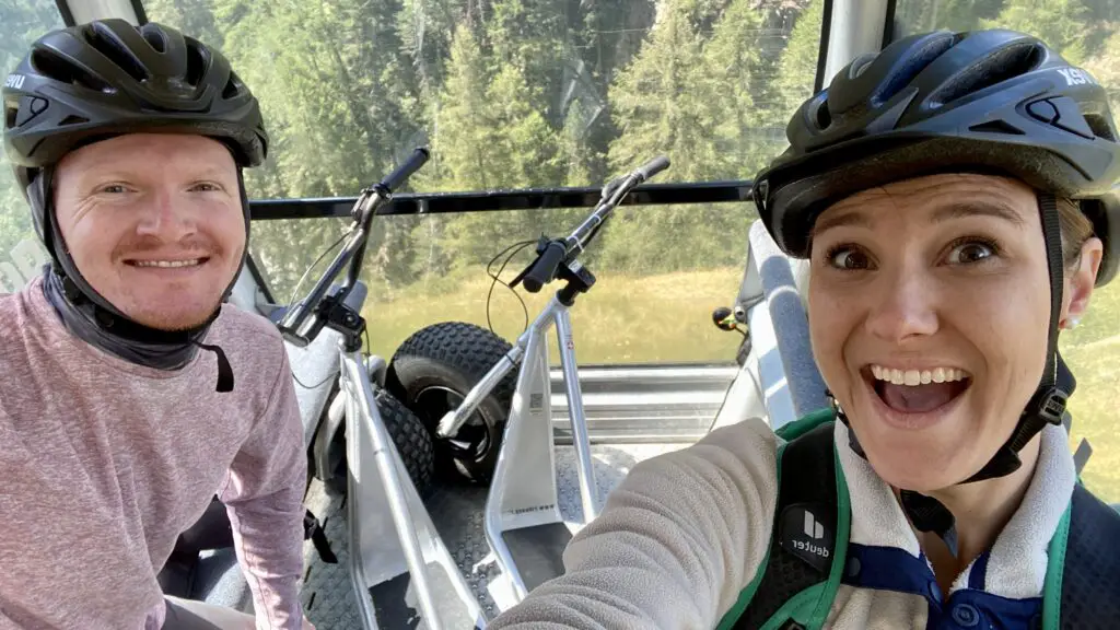 jana and brett riding a cable car with mountain scooters in zermatt 