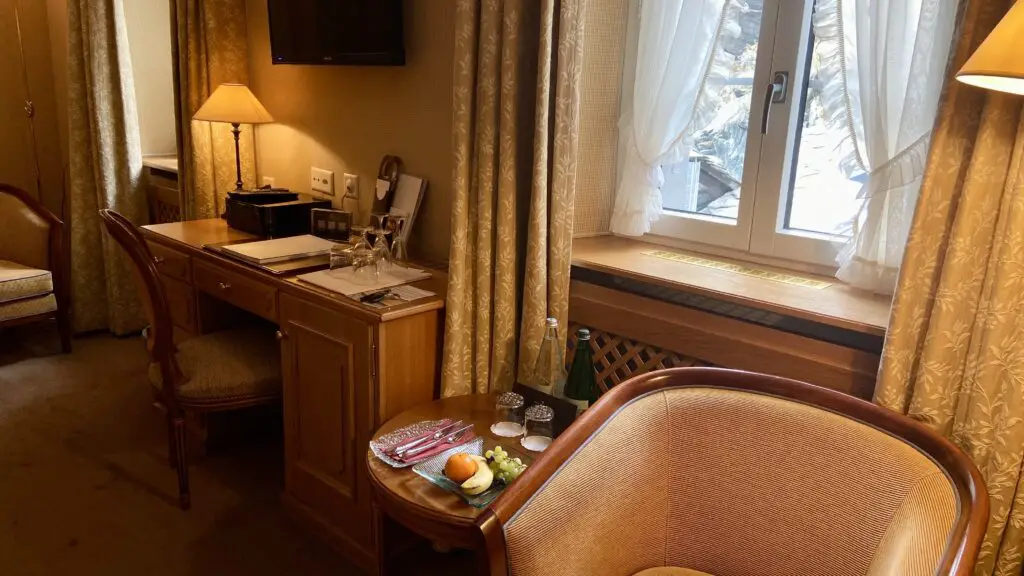 desk and chair and complimentary fruit in zermatt hotel 4 star
