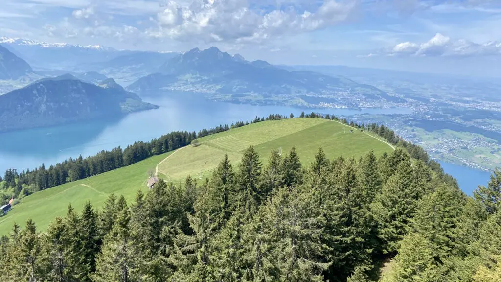 view of green fields and pilatus and swiss city of lucerne from the rotstockweg mt rigi switzerland