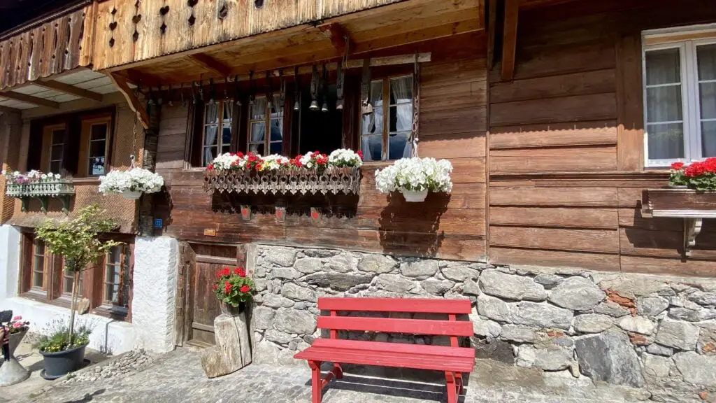 home with flowers and red bench on Brunngasse street in brienz switzerland