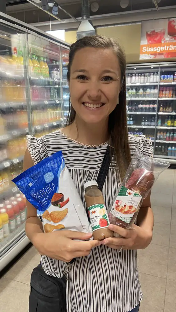 jana with salami sandwich, paprika chips, and fruit smoothie from migros grocery store switzerland