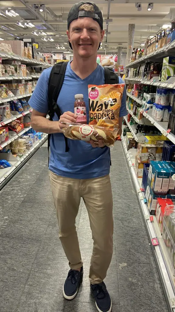 brett with a ham sandwich, paprika chips, and berry smoothie from coop grocery store switzerland