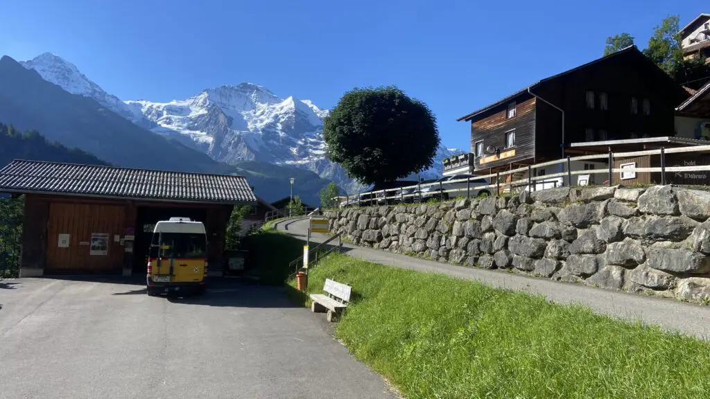 view of the bus stop in isenfluh switzerland with jungfrau mountain in the background