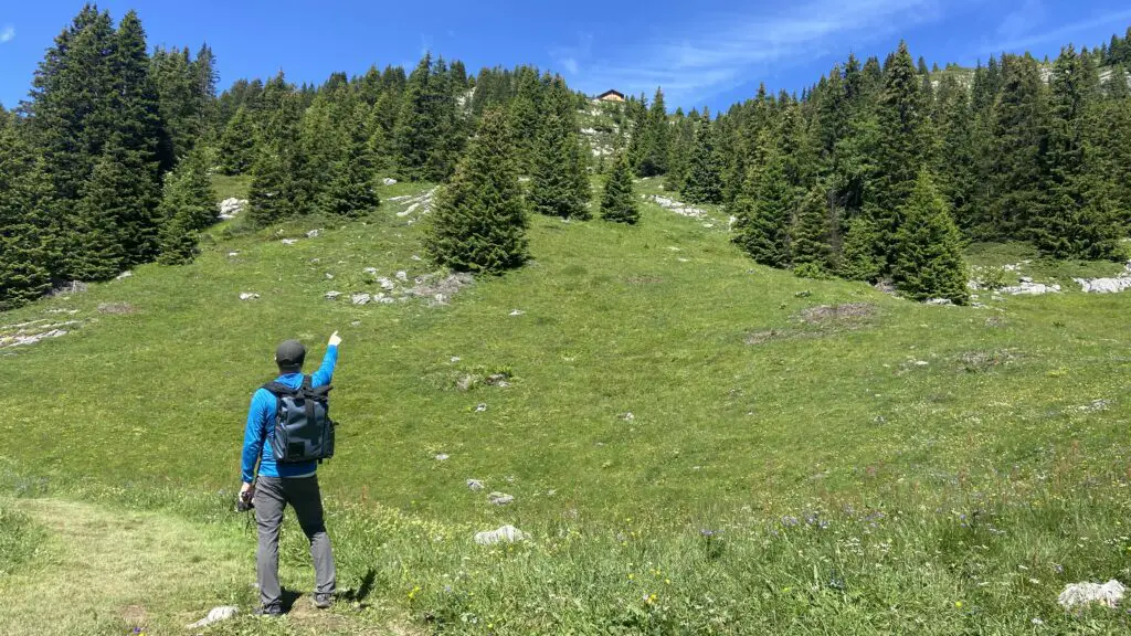 brett pointing up at the lobhornhutte from a hiking trail above sulwald switzerland