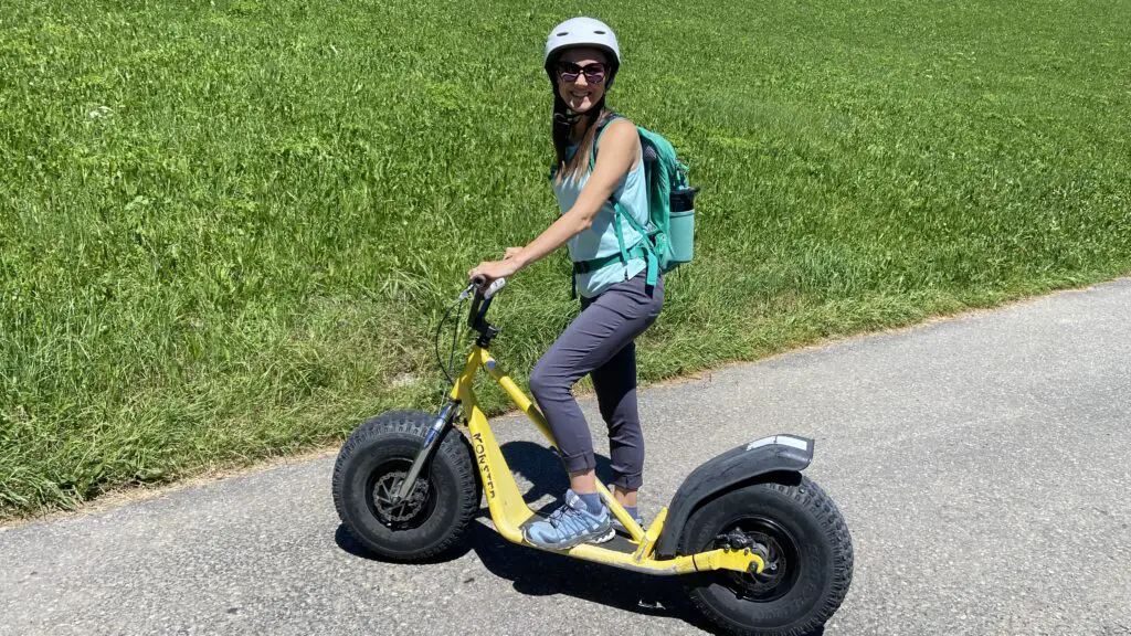 jana standing on a trottibike mountain scooters in sulwald switzerland