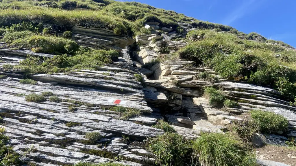 red and white trail sign and rocky ascent to tanzbödeli