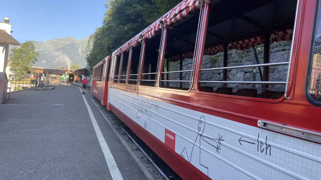 red and white passenger car at brienz rothorn station