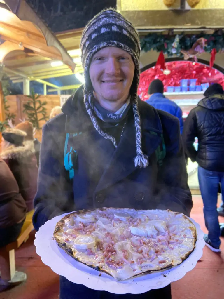 aplins in the alps eating flammkucken tarte flambee at colmar christmas market france