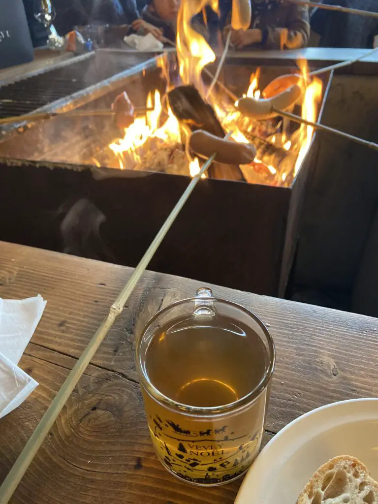 roasting a sausage at vevey switzerland christmas market with christmas tea