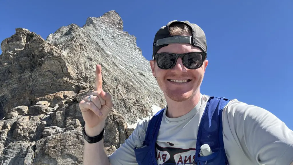 Brett pointing up to the matterhorn after hiking to the hornli hut in zermatt switzerland